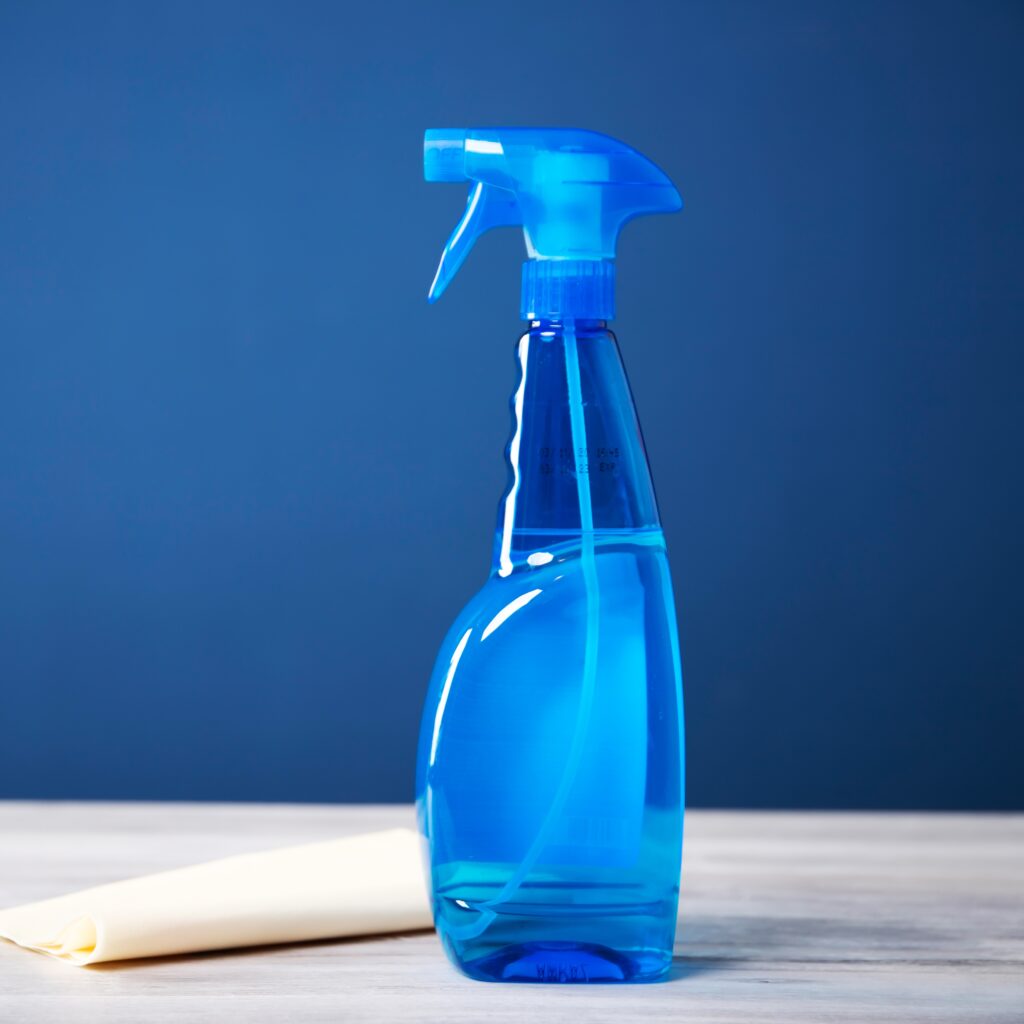 Cleaning blue spray bottle with plastic dispenser and towel for coronavirus prevetion.