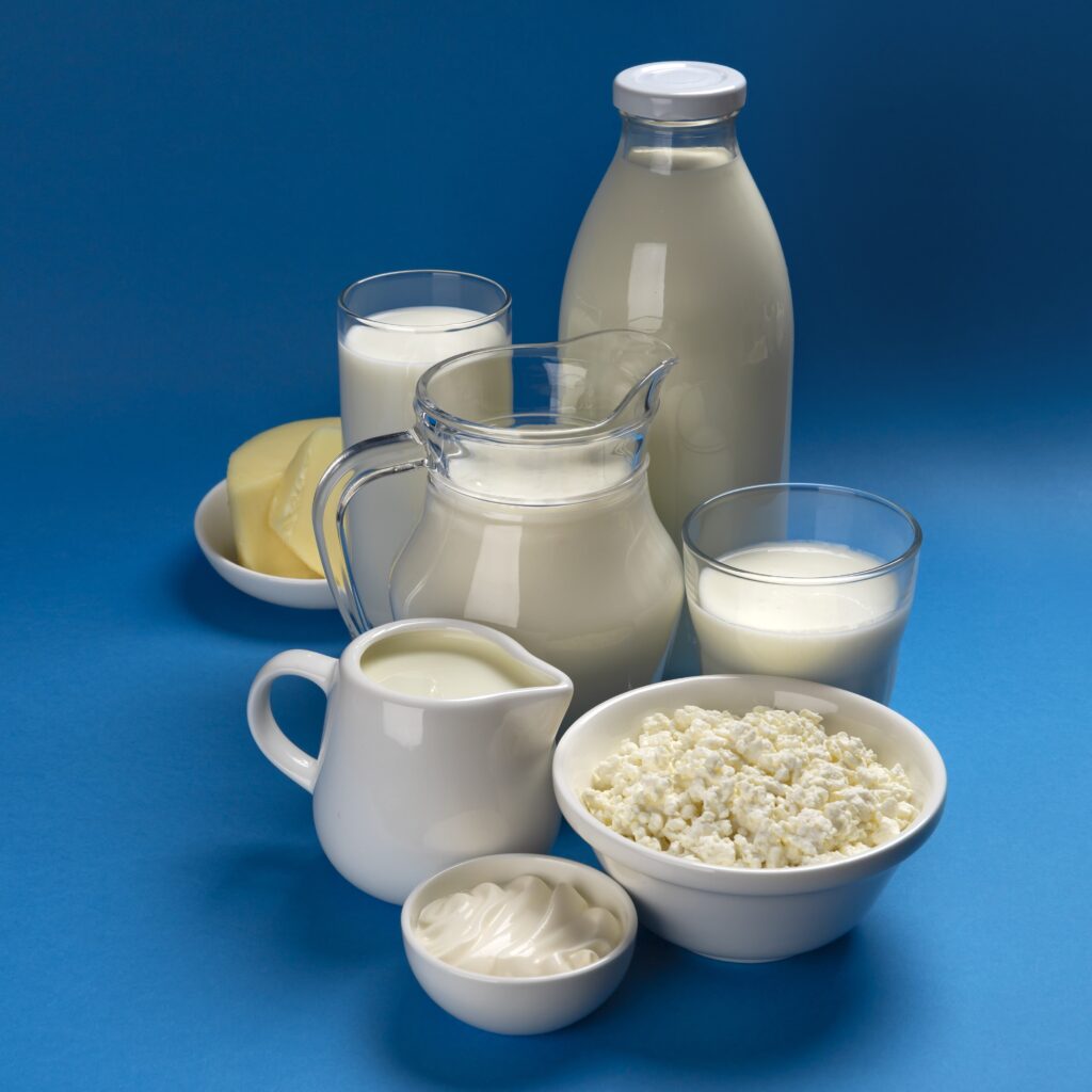 Set of dairy products on blue wooden background, assortment of milk, cottage cheese, sour cream and yogurt with copy space