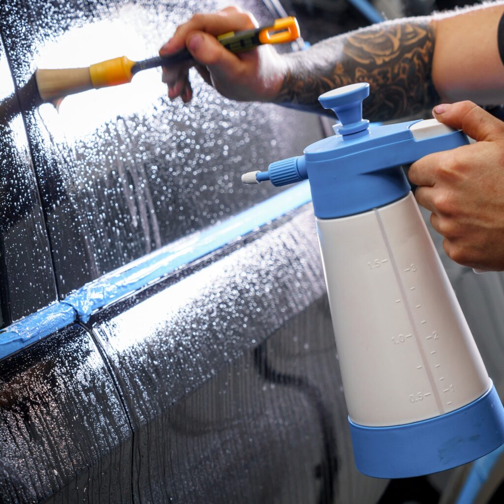 Sticker of a protective film on the headlight of a car in a car detailing studio